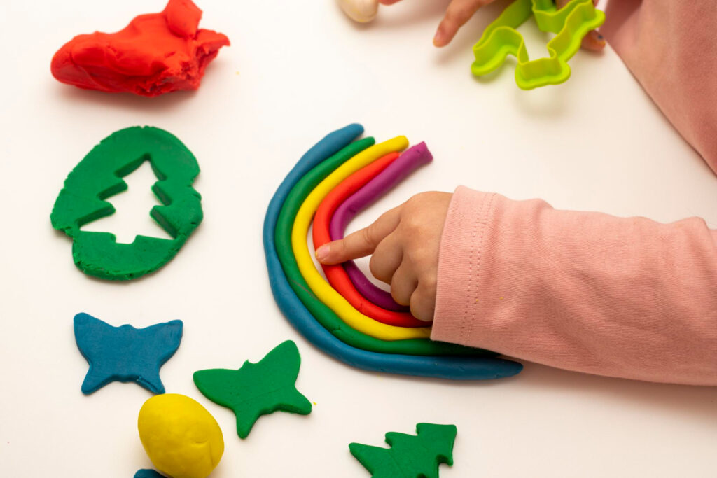 Dieťa tvorí tvary z mäkkej modelovacej hmoty pomocou formičiek